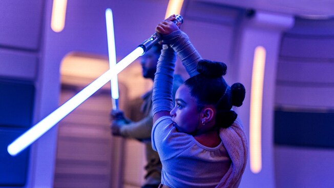 A young Guest wields a lightsaber in a class