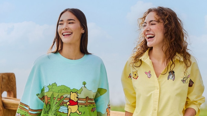 Two young women wearing Winnie the Pooh themed tops