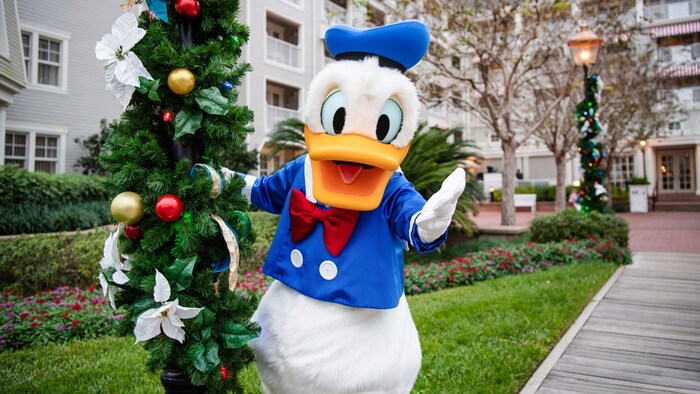 Donald Duck posando junto a un poste de luz con guirnalda festiva en Disney’s Yacht Club Resort