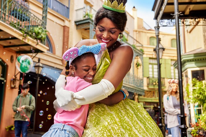 A girl hugging Princess Tiana in New Orleans Square at the Disneyland Resort