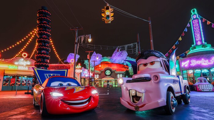 Lightning McQueen and Mater dressed in Halloween costumes at night in Cars Land