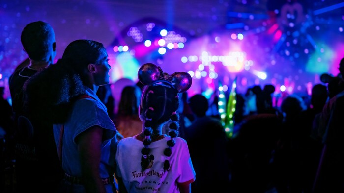 Guests taking in dazzling lights and projections during the night at the Disneyland Resort.