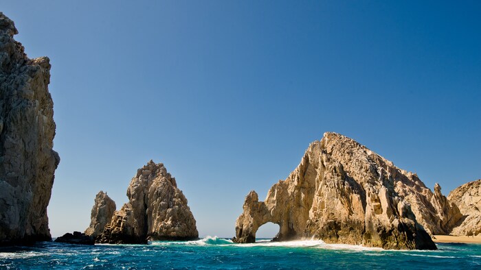 Deux formations rocheuses en forme de montagne se dressent au-dessus des vagues