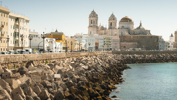 Des blocs de béton fortifient le littoral à côté de vieux bâtiments à Cadix, en Espagne