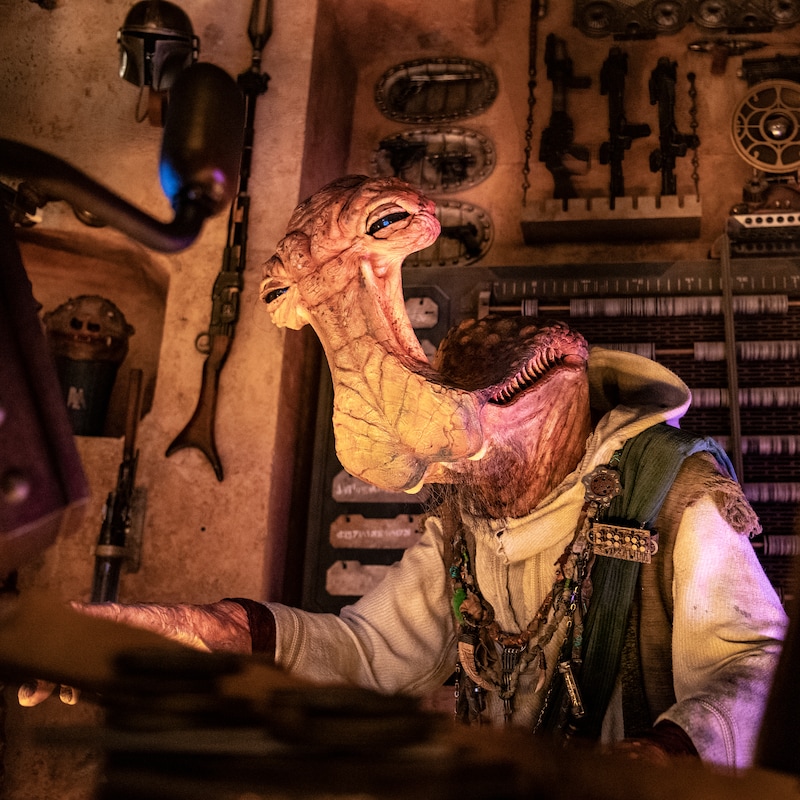 Dok Ondar, un alienígena Ithoriano de Star Wars cuya cabeza se asemeja a un tiburón cabeza de martillo, trabajando en su taller