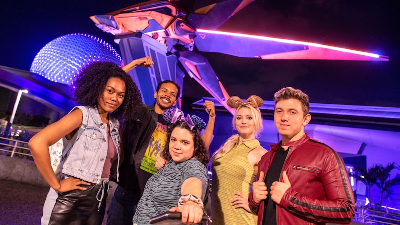  5 young adults pose for a photo at the entrance to the Guardians of the Galaxy Cosmic Rewind attraction