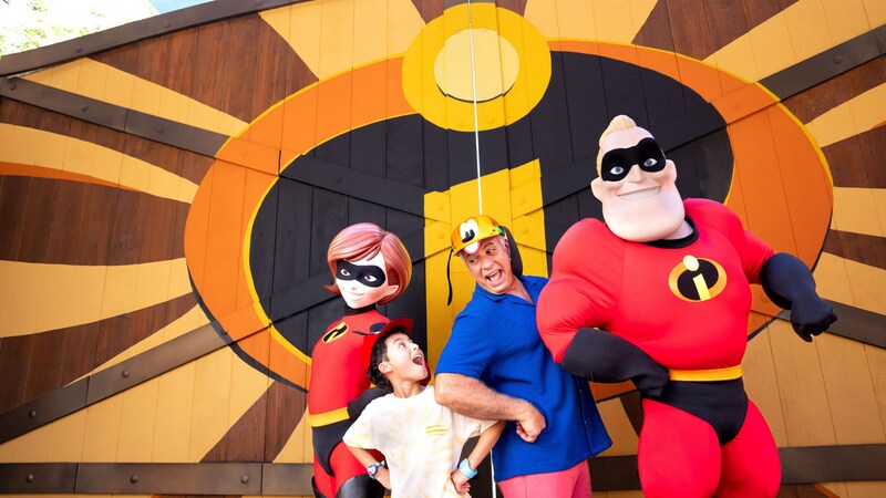 Un padre feliz y un hijo se interponen entre figuras de Mr. y Mrs. Parr de la película “The Incredibles”