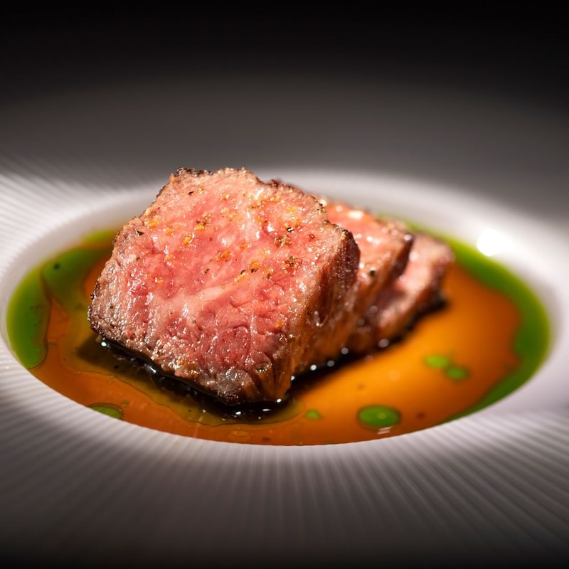 Un plat avec des tranches de bœuf Wagyu et de la sauce