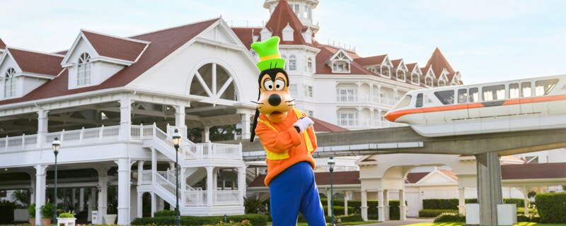 Goofy posing outside Disney’s Grand Floridian Resort & Spa as the monorail approaches  