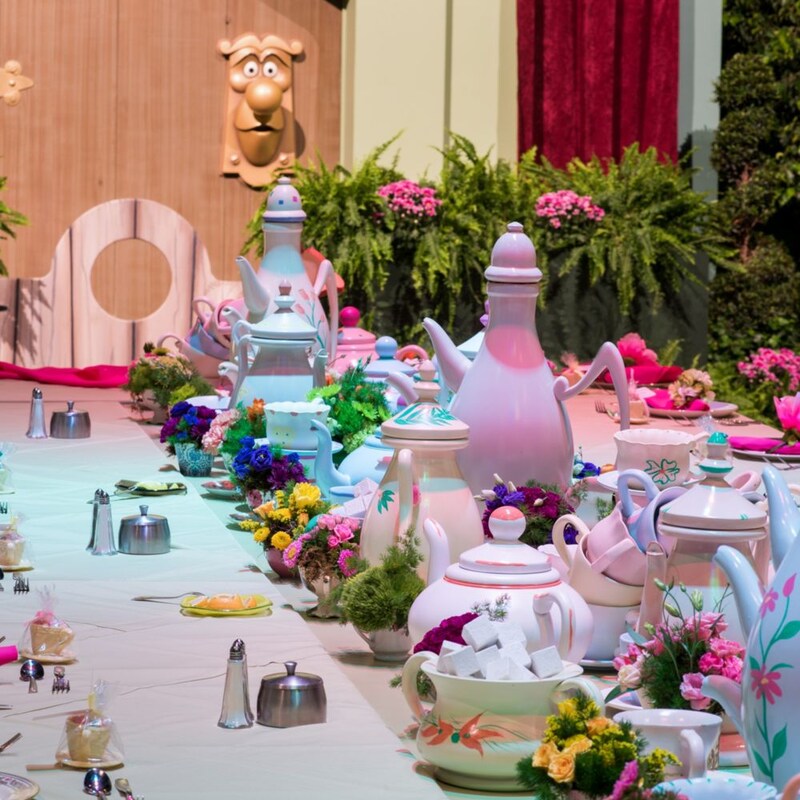 A large dining table decorated like The Mad Hatter’s tea party at an Alice in Wonderland themed event