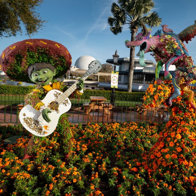 Topiary figures of Miguel in a sombrero playing a guitar and Dante from the Disney movie Coco.