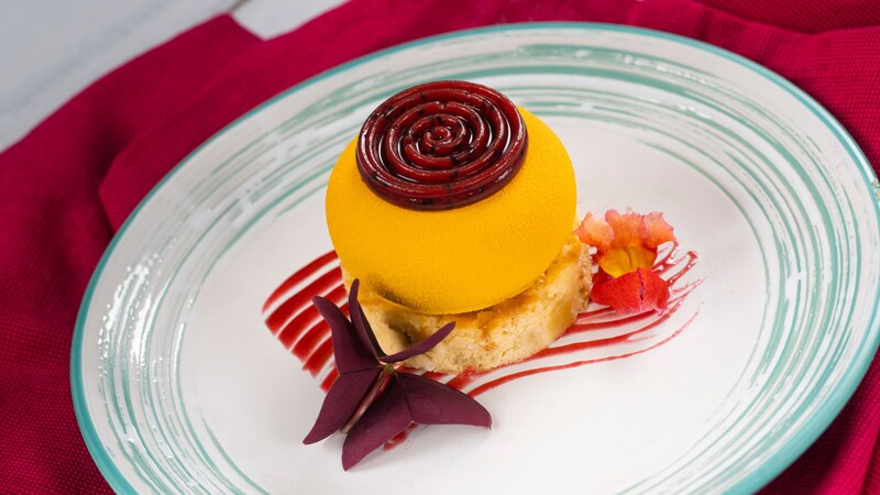 A portion of Passion Fruit filled Mango Cheesecake from Vibrante & Vivido at the Epcot International Festival of the Arts
