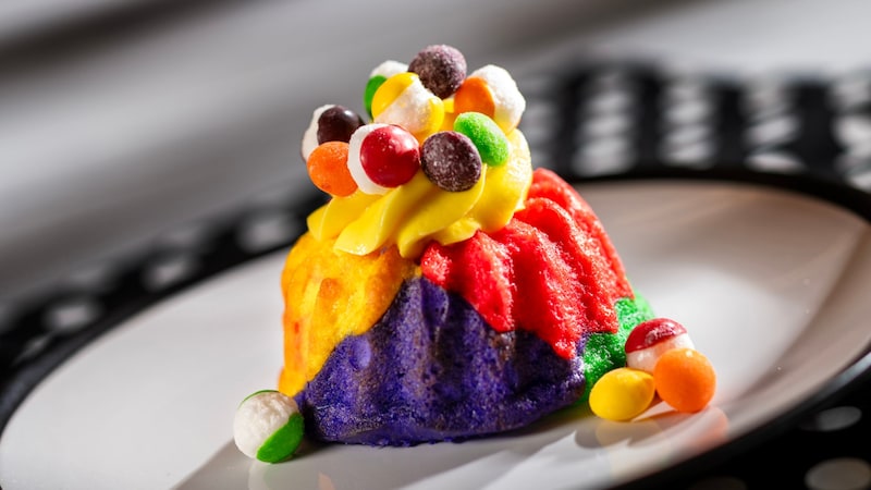 The Color Scheme Cake topped with whipped cream and pieces of candy