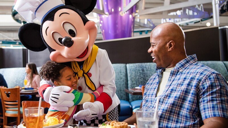 Le chef Mickey fait un câlin à une jeune fille au Chef Mickey’s dans le Disney’s Contemporary Resort