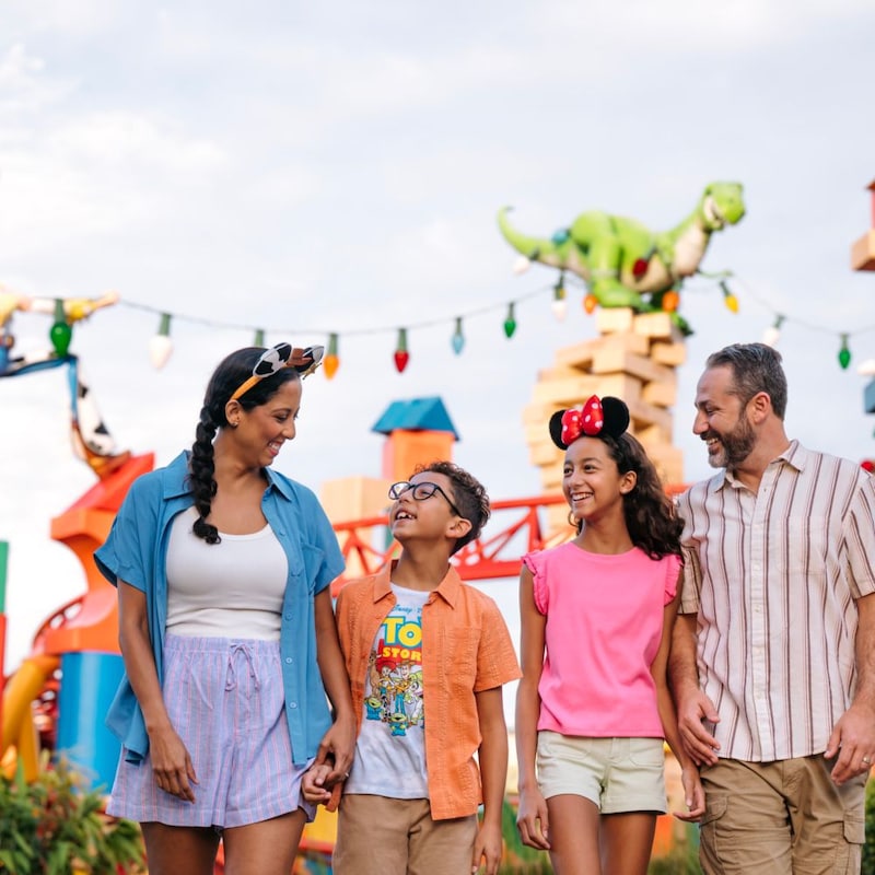 A young family of 4 walking through Toy Story Land at Disney’s Hollywood Studios theme park