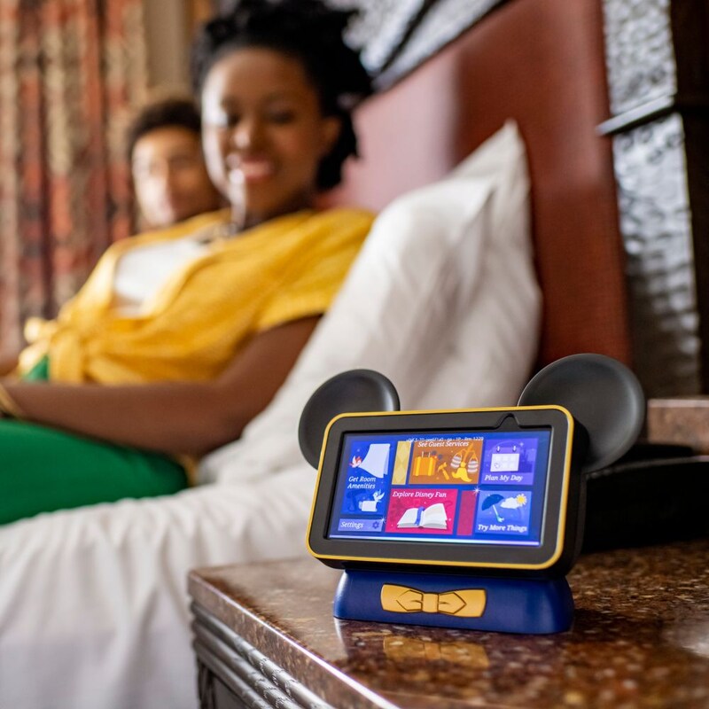 Duas pessoas deitadas na cama ao lado de um tablet Hey Disney