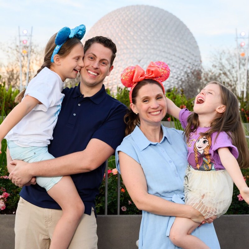 A family of 4 posing near Spaceship Earth