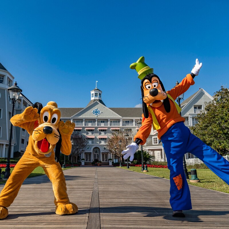 Dingo et Pluton posant pour une photo sur une passerelle menant au Disney’s Yacht Club Resort