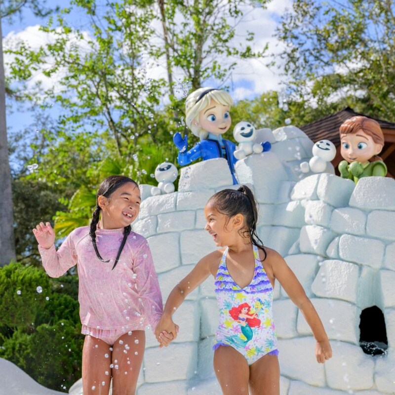 Two girls in swimsuits playing by a snow castle with Princess Elsa, Princess Anna and Olaf at Tike's Peak