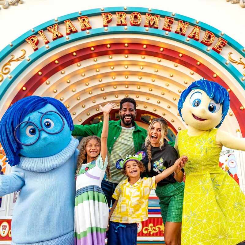 A family takes photos with the characters Joy and Sadness from the Disney and Pixar film Inside Out
