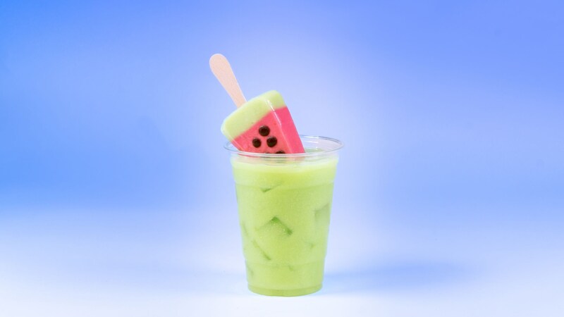 A watermelon shaped popsicle resting in an iced drink, available during Bluey's Best Day Ever