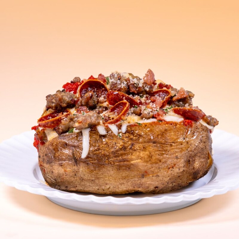 A baked potato loaded with pepperoni, sausage and melted cheese, available during Bluey's Best Day Ever