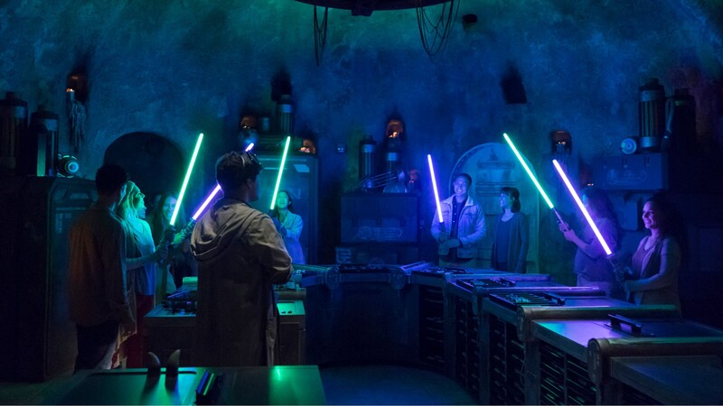Un grupo de Visitantes hace sables de luz en Savi’s Workshop, en Star Wars: Galaxy’s Edge