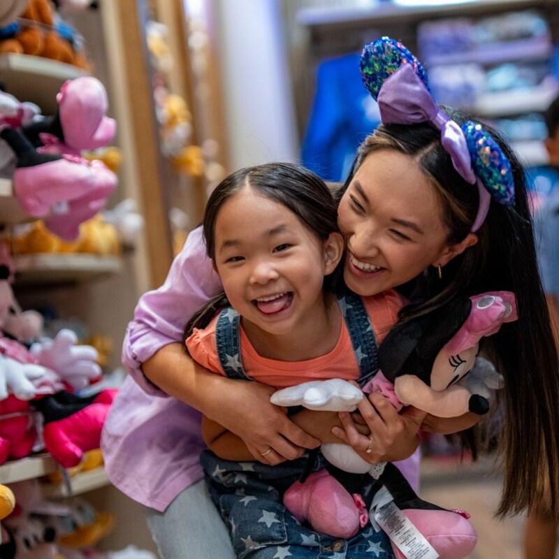 A woman embracing a child holding a Minnie Mouse doll