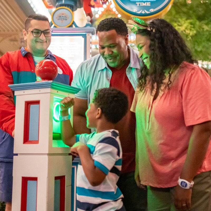 A child tapping a Magic Band Plus to a Disney theme park entrance