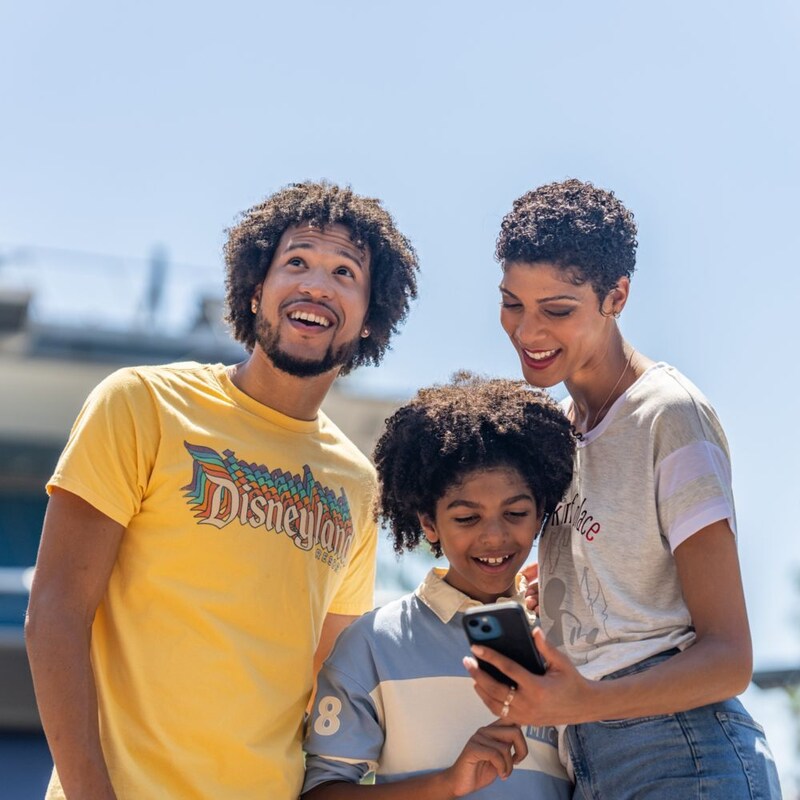 2 adults showing a child a phone 