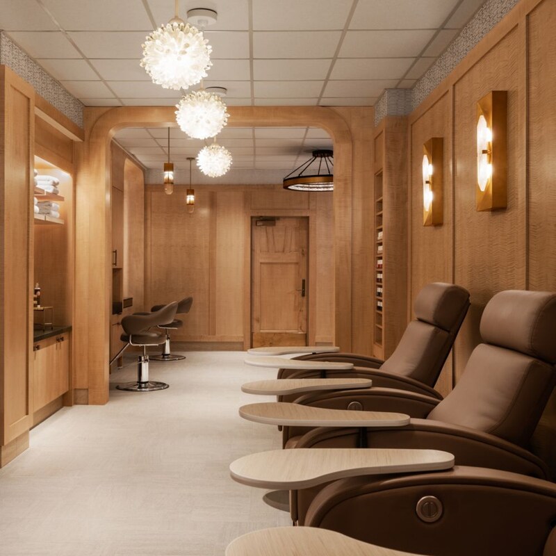 A manicure and pedicure treatment area, and a hair styling area in the background.