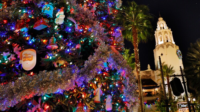 A decorated Christmas tree near a cathedral and palm trees