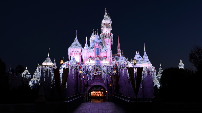 The façade of Sleeping Beauty Castle decorated with icicle lights and illuminated at night