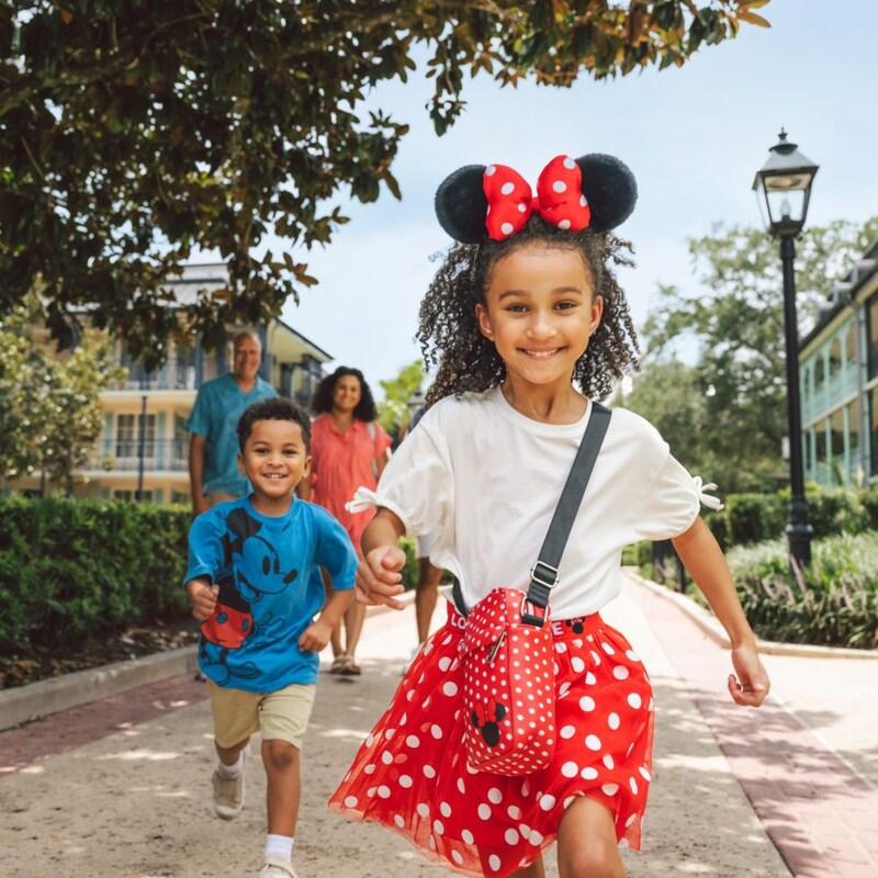 Two children running ahead of their parents as they walk through Disney’s Port Orleans Resort