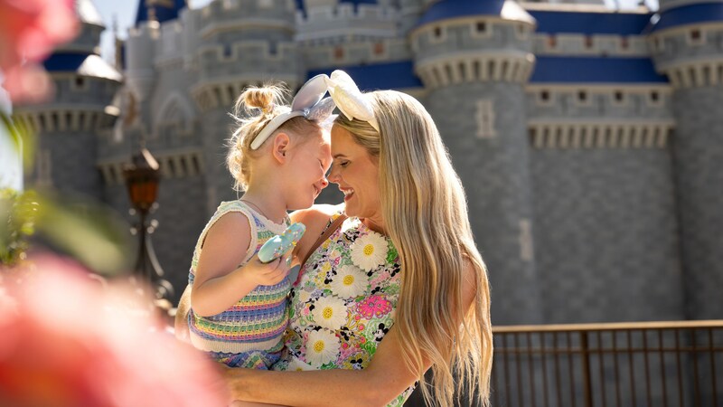 A mother embracing her daughter near Cinderella Castle at Walt Disney World Resort