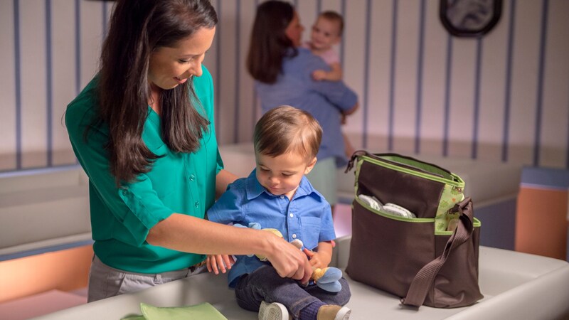  A mother tending to a toddler on a changing table in a Baby Care Center