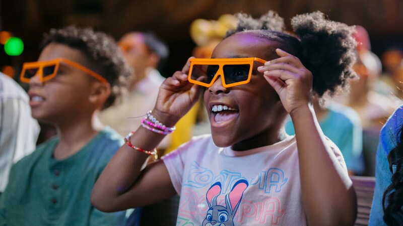  A family wearing orange 3D glasses watching a show