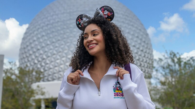 Guest wearing a pullover and ear headband from the Mickey and Friends 2026 collection at Spaceship Earth in Epcot