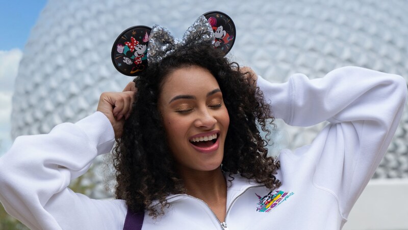 Guest in Mickey Mouse pullover and ear headband from the Mickey and Friends 2026 collection at Spaceship Earth in Epcot