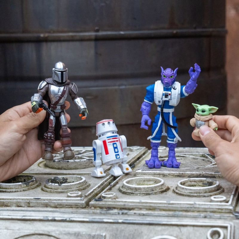 Hands displaying Star Wars action figures