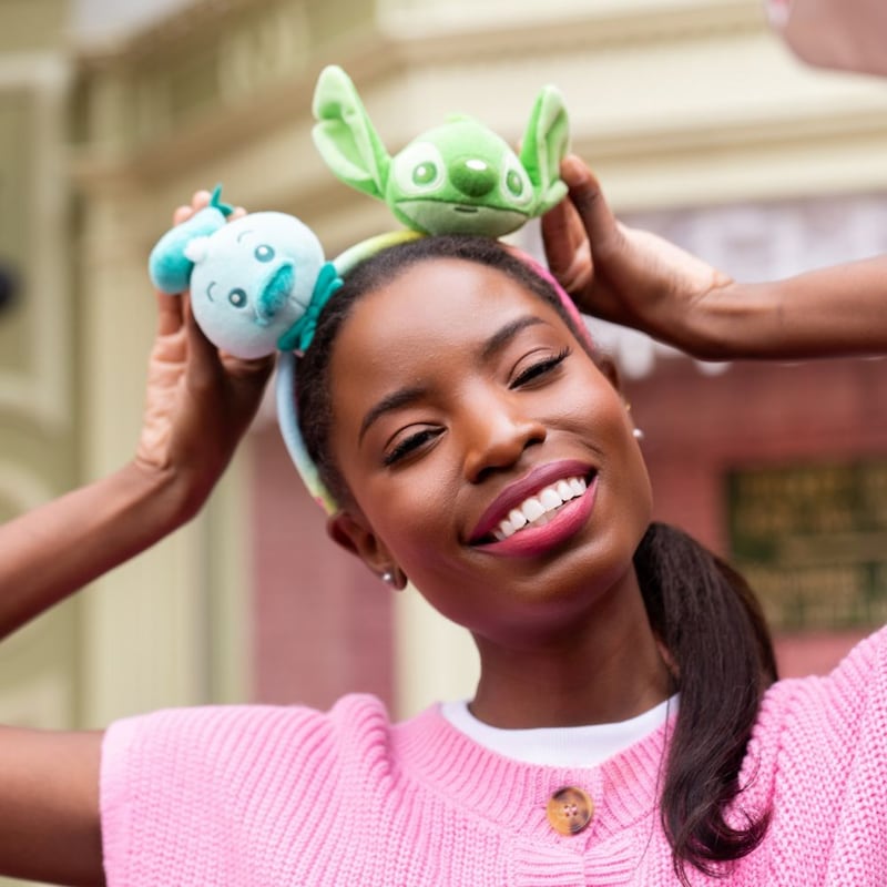 A woman wearing a Create Your Own Headband featuring Stitch and Donald Duck
