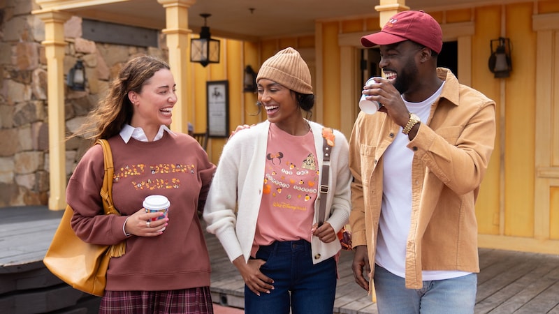 3 Guests laughing together in Walt Disney World fall apparel