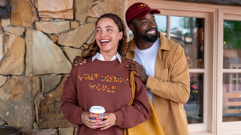 2 Guests smiling together while wearing Walt Disney World fall apparel