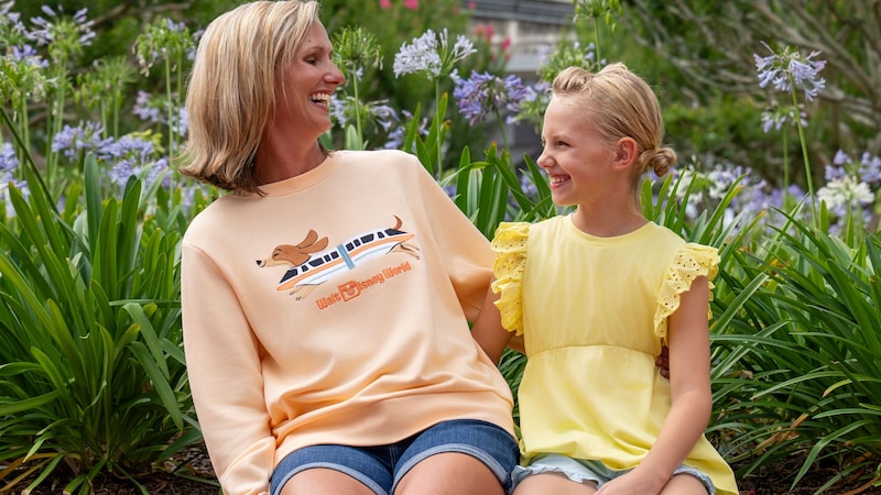A mother and daughter laughing together near Spaceship Earth at Epcot