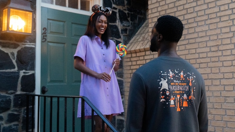2 Guests in Mickey's Not So Scary Halloween Party apparel while standing on a doorstep