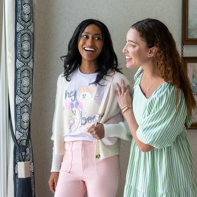 2 Guests laughing together, with one wearing a Hey Boo Disney character tee