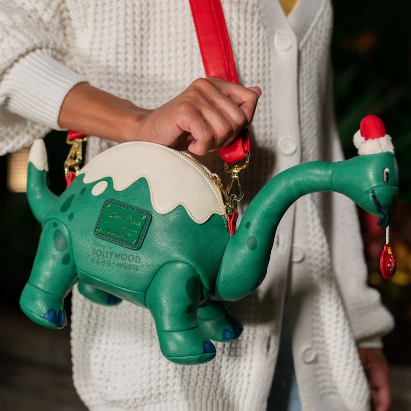 A purse shaped like Dinosaur Gertie wearing a Santa hat from the Disney Holiday Collection