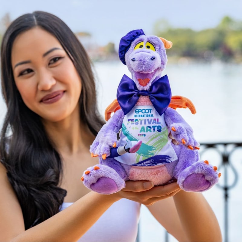 A Guest holding an Epcot International Festival of the Arts 2026 Figment plush
