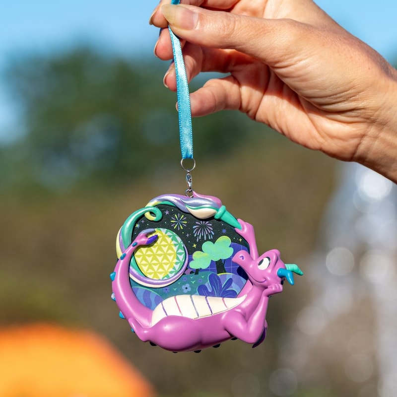 A hand holding a Figment ornament