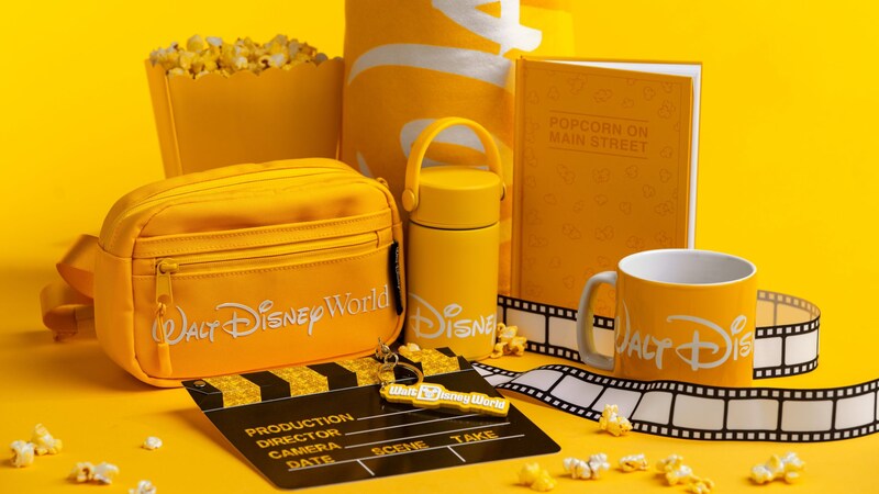 Walt Disney World merchandise,, including a belt bag, water bottle, mug and a journal reading "Popcorn on Main Street"